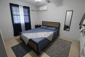 Crocus HillDolphin Villas AXA的一间卧室配有一张带蓝色床单和镜子的床