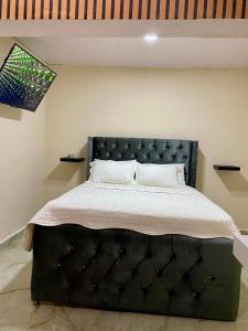 圣斐利-银港LA Casita de Plata的一间卧室配有一张大床和黑色床头板