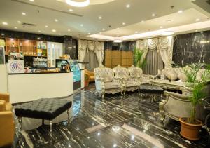 吉达Wow Hotel Jeddah的一间设有椅子和酒吧的等候室