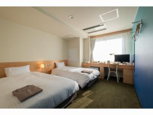 HukueSERENDIP HOTEL GOTO的酒店客房设有两张床、一张桌子和一台电视。