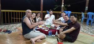北市Pac Ngoi Village's homestay (Ba Be Lake)的一群坐在桌子旁吃饭的人