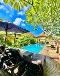 蓝梦岛Dream Beach Hostel Lembongan的房屋旁的游泳池配有椅子和遮阳伞