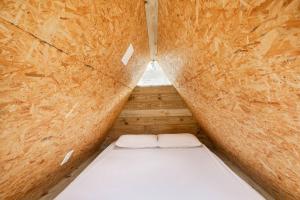 圣塞巴斯蒂安SURFSIDE MARESIAS的小房间,木墙里设有一张床