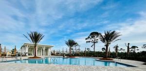 圣乔海滩Sea Grove Beach Resort in WindMark Beach North 3 bedroom 2 bathroom in New Duplex的一座棕榈树游泳池和一座建筑