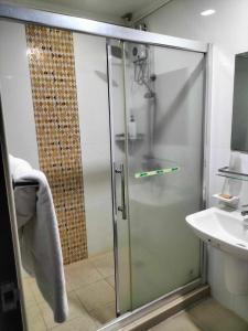 安吉利斯PJ INN HOTEL的一个带水槽的玻璃淋浴间