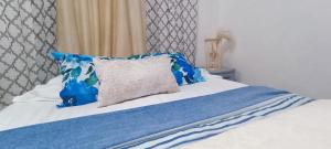 坎昆Casa Calis Cancún的一张带蓝色和白色床单的床和枕头