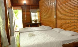 Tân PhúDu Nam Riverside Tour Trọn Gói的砖墙客房的两张床