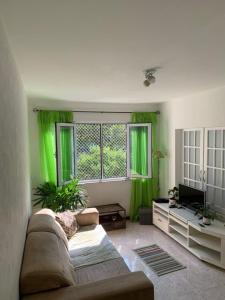 里约热内卢Apartamento Aconchegante na Zona Sul, Botafogo Rj的客厅配有绿色窗帘和沙发