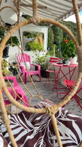 派西亚Paihia Loft Walk to Beach, Eats and Culture的庭院里一组粉红色的桌椅
