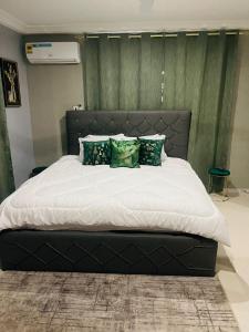 OyarifaLuxury Townhome in Oyarifa的一间卧室设有一张带绿色墙壁的大床