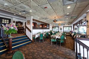柏斯海滩Boardwalk Plaza Hotel的用餐室配有桌子和绿色椅子