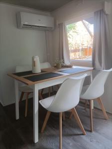 科特布斯Tinyhaus idyllisch am Waldesrand的餐桌、两把白色椅子和窗户