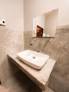 涛岛英菲尼迪盖斯特豪斯旅馆的浴室设有白色水槽和镜子