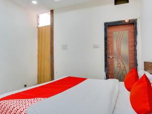 博帕尔OYO Hotel Shivansh的一间卧室配有一张带红色枕头的床和一扇门