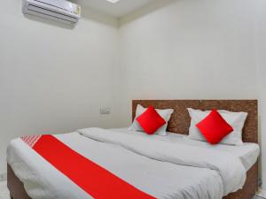 博帕尔OYO Hotel Shivansh的一间卧室配有两张带红白色枕头的床