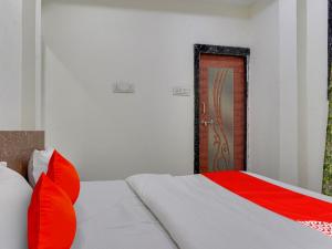 博帕尔OYO Hotel Shivansh的一间卧室配有一张带红色枕头的床和一扇门