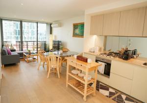 墨尔本Infinity Lux Apartment的厨房以及带桌椅的起居室。