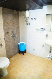 孟买Andheri Sports Complex - VIP Guest House的一间带卫生间和蓝色桶的浴室