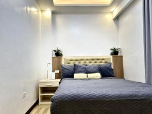 SibalomCasa Dee Leticia的一间卧室配有一张带蓝色床单和两株植物的床