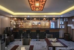 胡志明市Golden Dragon Hotel Sài Gòn的餐厅设有酒吧,配有桌椅