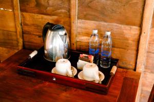 德格拉朗Taksu Sebatu Villa的一个带茶壶和2瓶水的托盘