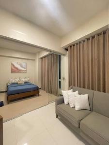 Punta EngañoThe Mactan Suite at The Mactan Newtown Resort的客厅配有沙发和1张床