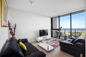 Werribee SouthWyndham Harbour Luxury Bayside Haven with parking的客厅设有黑色沙发和大窗户