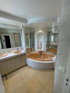 旺斯La Bergerie B&B的大型浴室设有两个盥洗盆和一个大浴缸。
