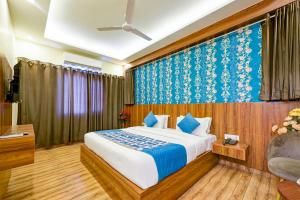 新德里Rosewood Suites Near IGI Airport的一间卧室配有一张蓝色和白色壁纸的床