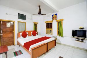 布巴内什瓦尔Goroomgo Upasana Bhubaneswar的一间卧室配有一张床和一台平面电视
