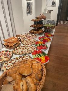 皮塞克白玫瑰大酒店的一张桌子,上面放着许多不同类型的面包和糕点