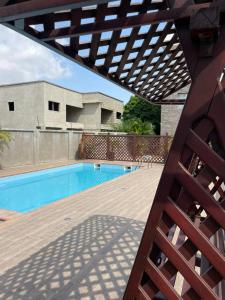 阿克拉Stay Play Away Residences - Luxury 4 bed, Airport Residential, Accra的一个带游泳池和木甲板的庭院