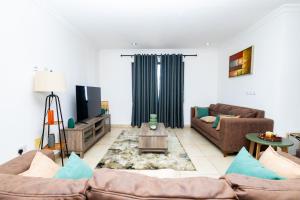 阿克拉Stay Play Away Residences - Luxury 4 bed, Airport Residential, Accra的客厅配有两张沙发和一台电视机