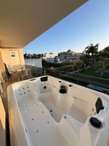 乌贾诺拉基耶萨Le Murge Del Salento Hotel b&b Depandance的阳台顶部设有大型白色浴缸。