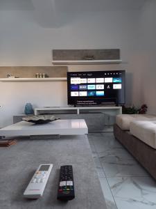 毕达哥利翁Νεόκτιστη βίλα, Χώρα Πυθαγορείου的客厅设有2个遥控器和电视