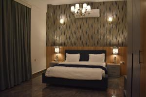埃尔比勒Motel Victoria Sky的一间卧室配有一张大床和两个带灯的床头柜。