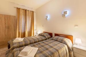 苏法利诺Genysweethome的酒店客房设有两张床和窗户。