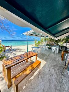 弗里德胡Bougainvillea Inn - Maldives的海滩上一把木凳,放在伞下