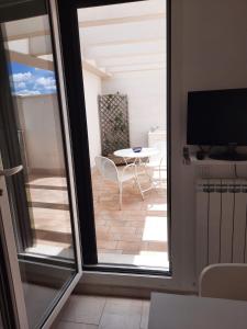 切萨雷奥港La Vela Apartaments - Porto Cesareo的阳台配有桌子和电视。