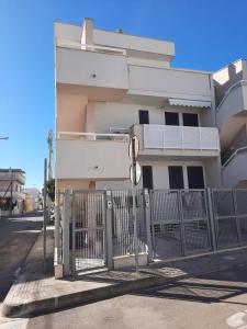 切萨雷奥港La Vela Apartaments - Porto Cesareo的白色建筑前的大门