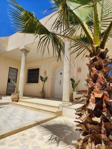 古莱比耶Villa Nour Kélibia的一座建筑前的棕榈树