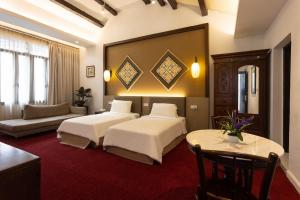 马六甲Hotel Puri Melaka的酒店客房,设有两张床和一张沙发