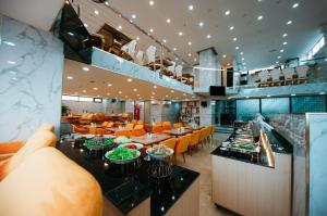 芽庄Napoleon Nha Trang Hotel的一间带桌椅的餐厅以及一间自助餐