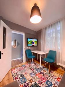 伊兹密尔İZMİR merkezde müstakil TEMİZ küçük ev的客厅配有两把椅子、一张桌子和一台电视