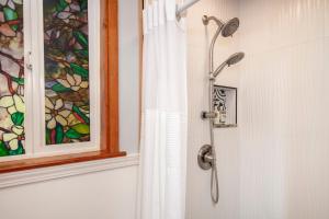 沃尔卡诺Aloha Junction Guest House - 5 min from Hawaii Volcanoes National Park的带淋浴的浴室,配有窗户和浴帘