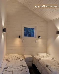 斯德哥尔摩möja stuga i Stockholms skärgård的一间卧室设有两张床和窗户。