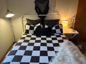 皇后镇Breakfast at Tiffanys的一张带黑白床单和枕头的床
