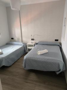 隆达Casa Daybru的酒店客房设有两张床,床上配有白色枕头