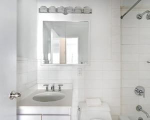纽约Lovely 4 BR in NYC!的白色的浴室设有水槽和卫生间。