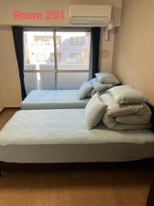 东京SkyHotel Ryogoku 駅徒歩4分的带窗户的客房内的两张床